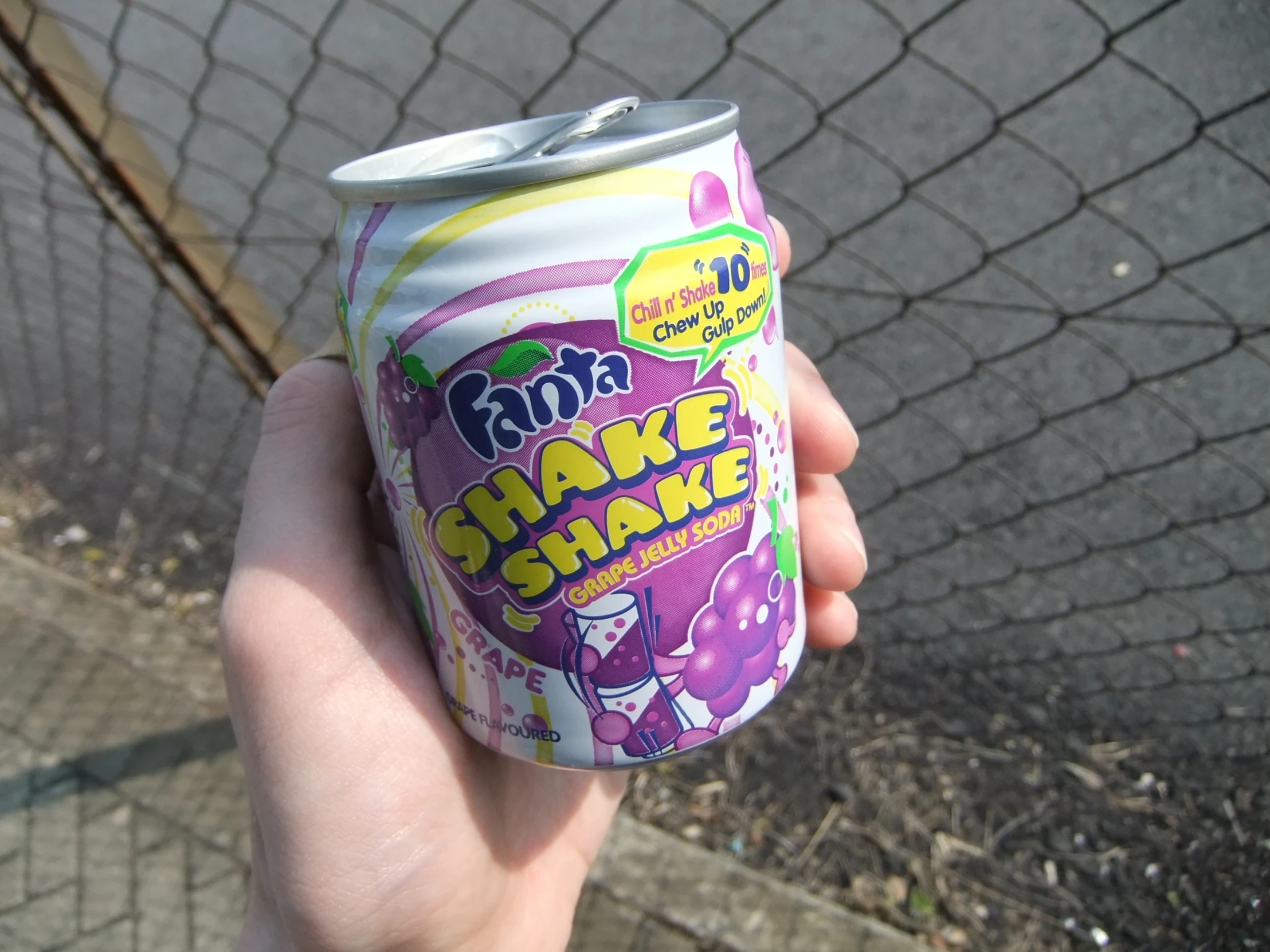 someone holding a canned drink on the street