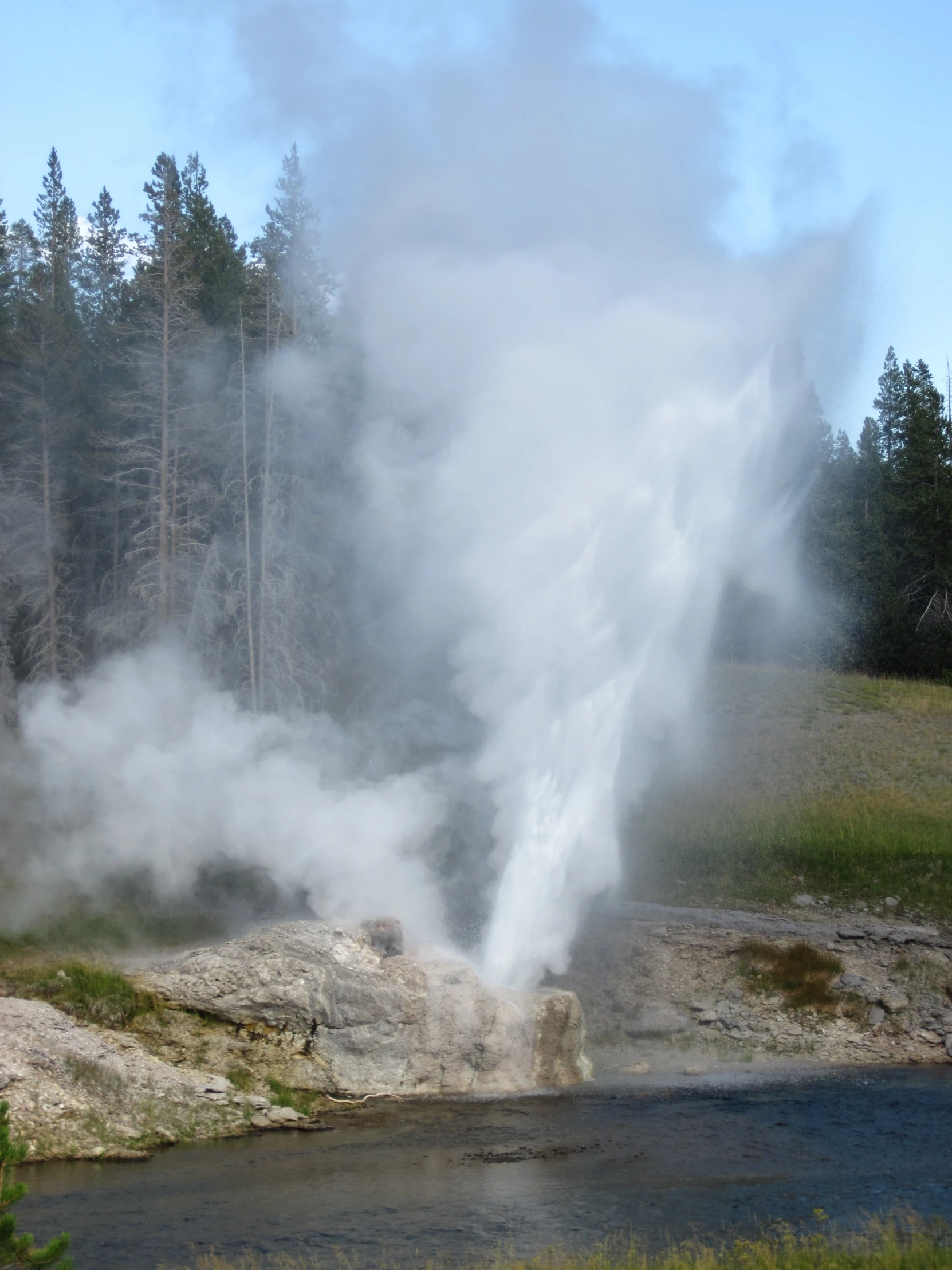 a stream of water coming from behind rocks