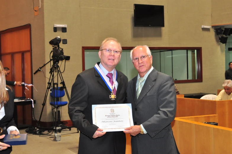 a man holding an award is presented by an official