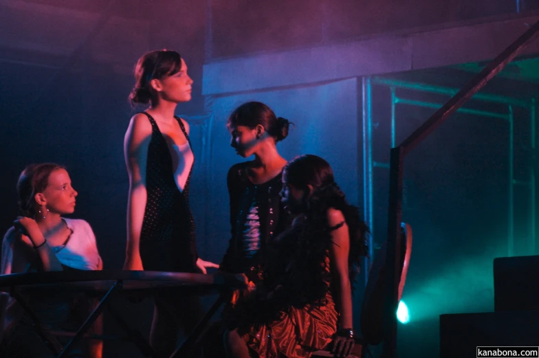 three women talking to each other on a stage