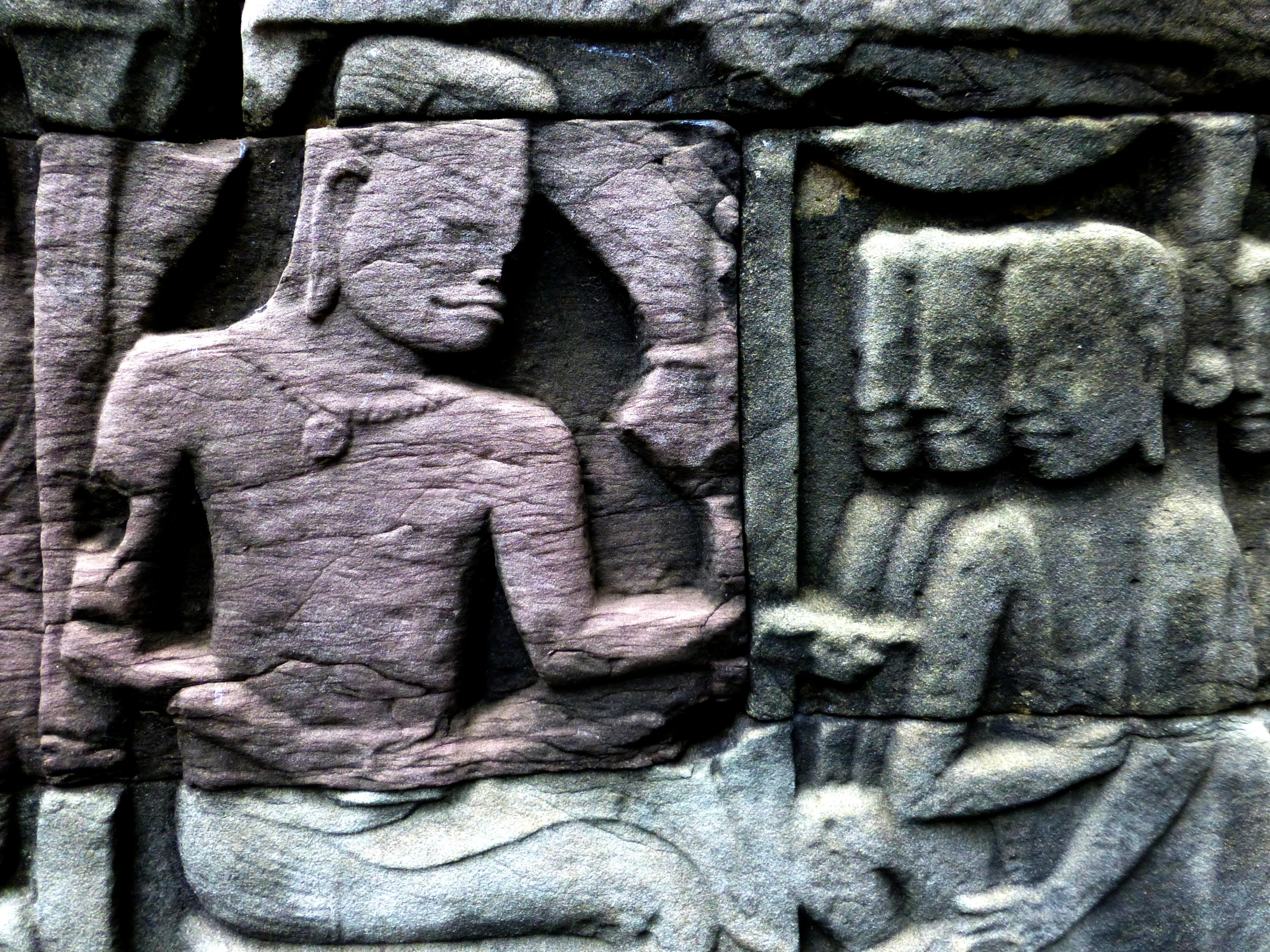 a closeup of a sculpture near some stone figures