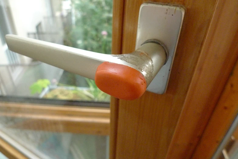 a close up view of a door handle with orange paint