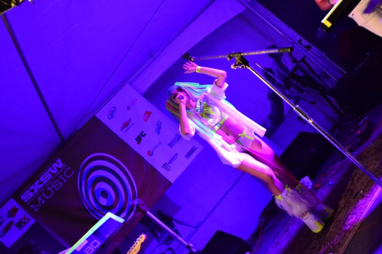 a performer on a stage that has a microphone in her hand