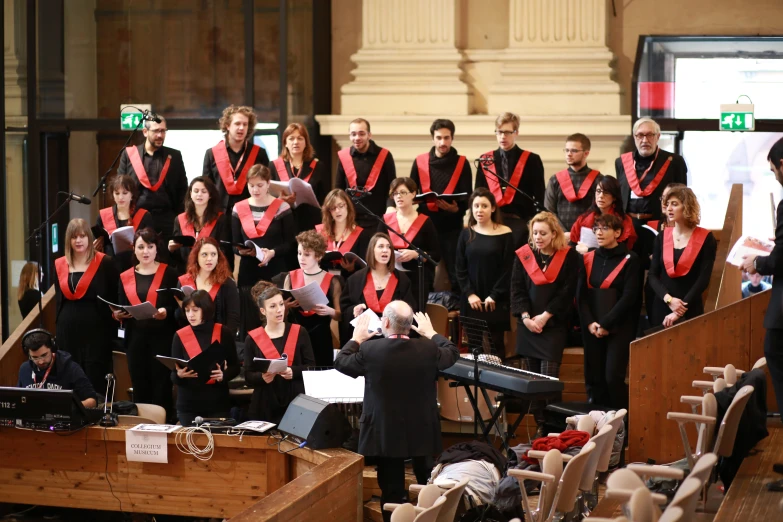 a choir in red and black clothes standing on a stage