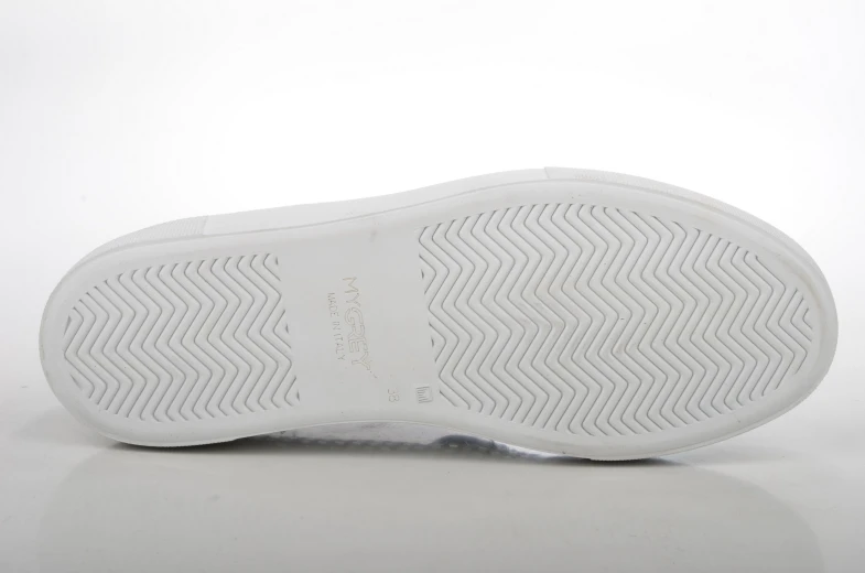 a white sneaker on top of a white surface