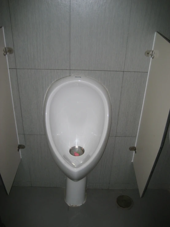 a bathroom with a urinal and two doors