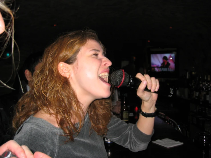 a woman holding a microphone with her mouth wide open