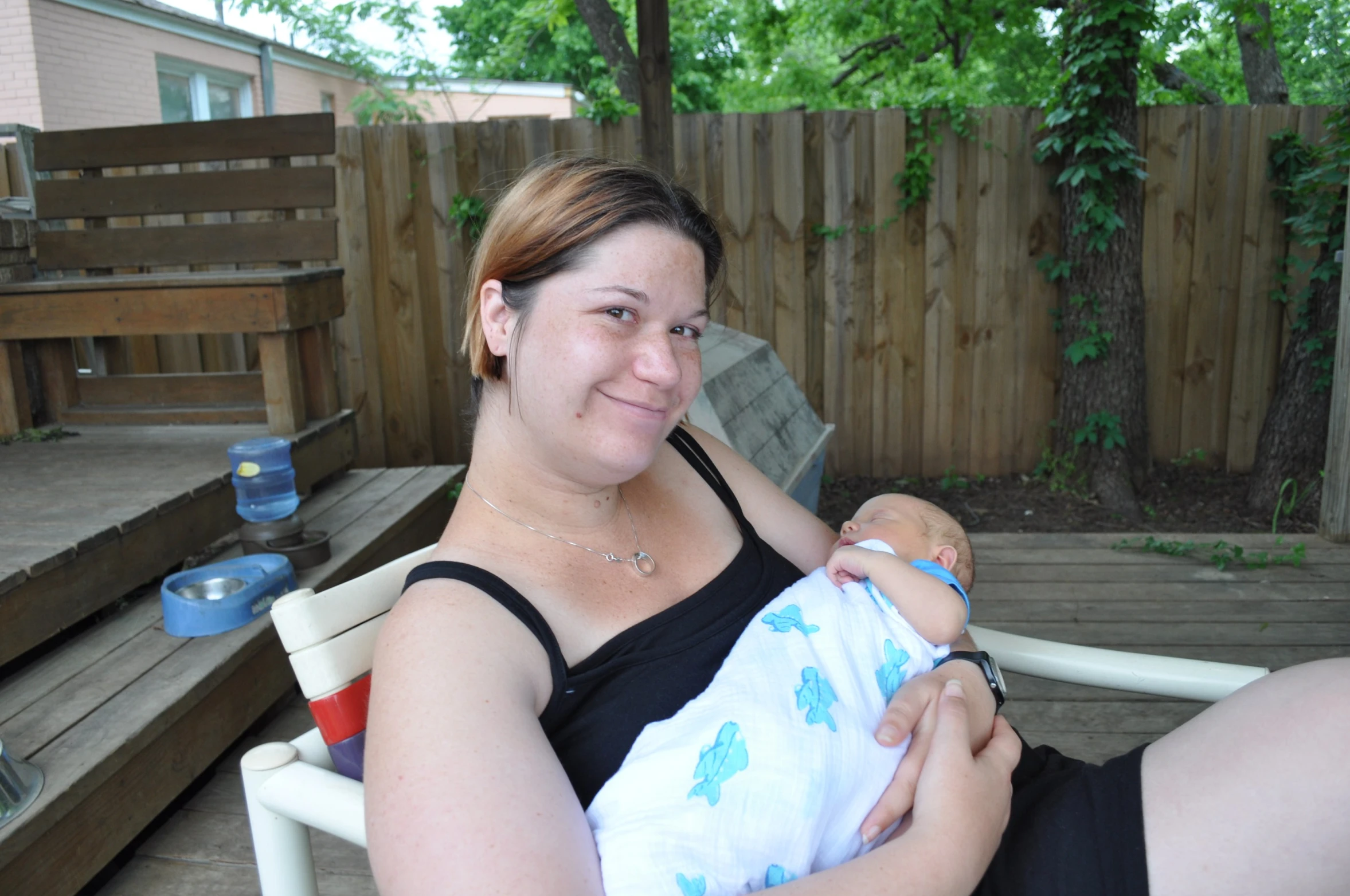 a woman smiling as she holds her infant