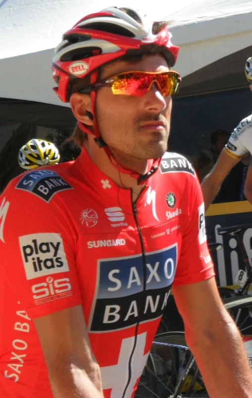 a cyclist in red is next to some other riders