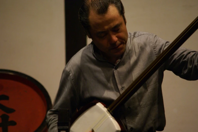 a man holding a japanese - style instrument in his left hand