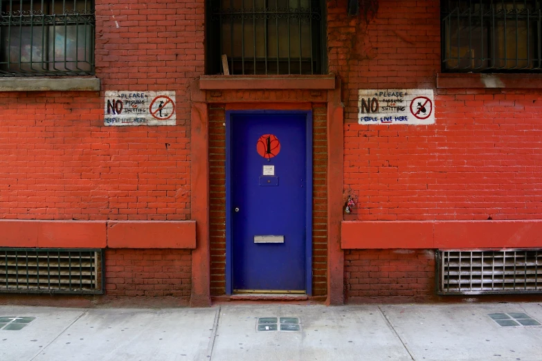 there is a blue door in front of a red building