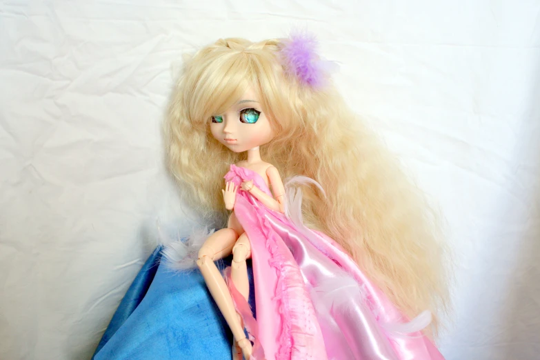 a doll is posed next to a blue bag