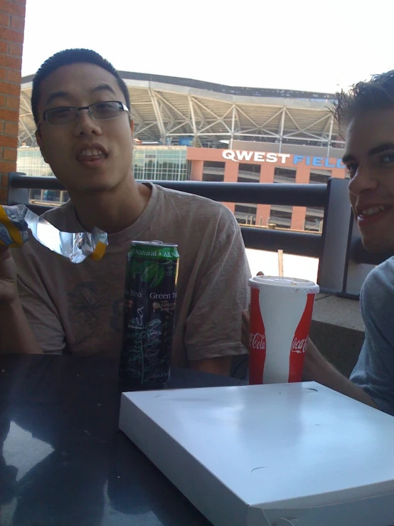 two men are sitting at a table with drinks