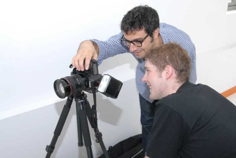 two men with a camera on a tripod