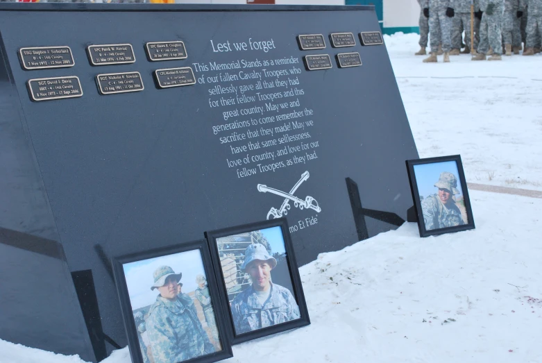 several pictures are placed in front of a memorial plaque