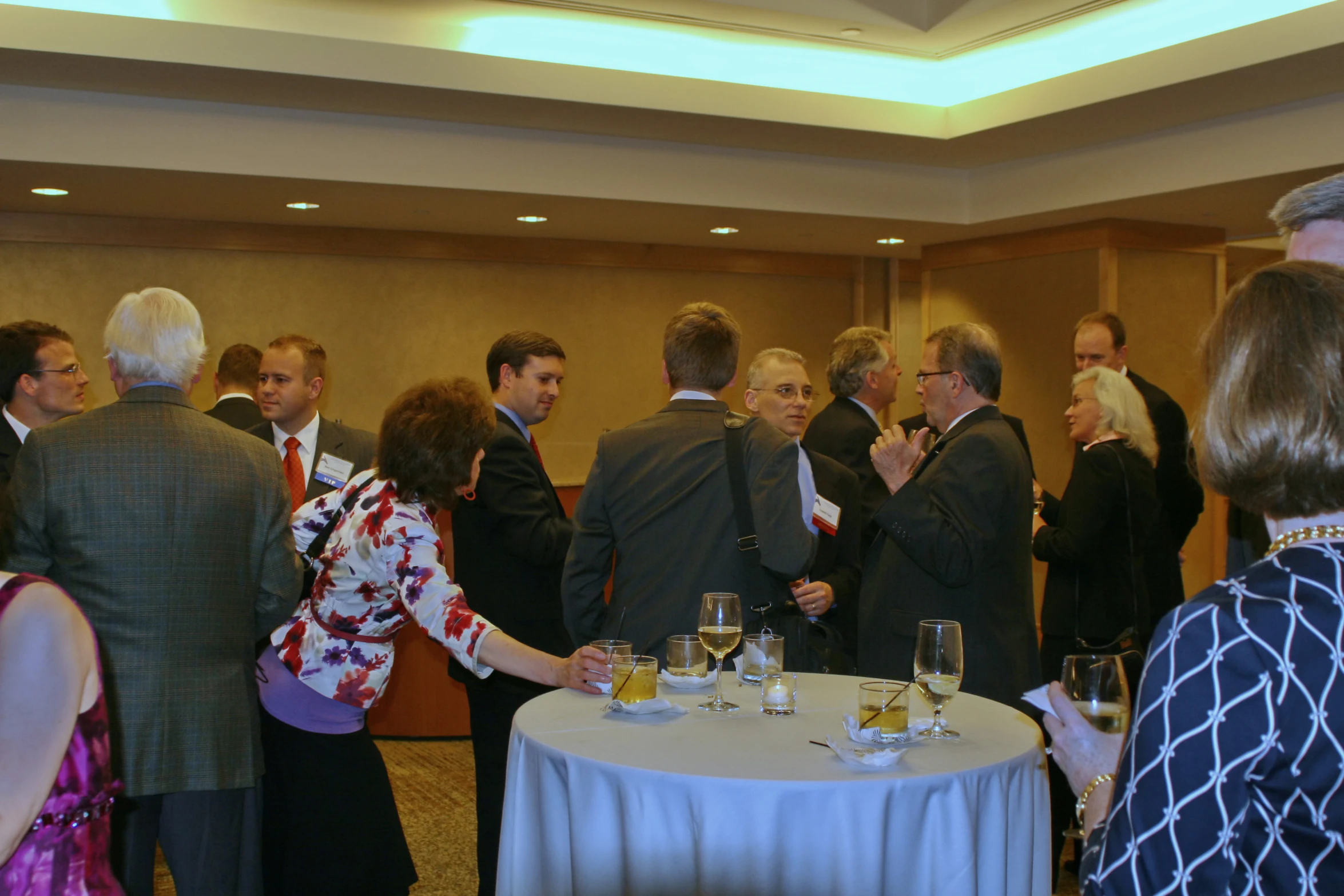 several people standing around a table with drinks in glasses