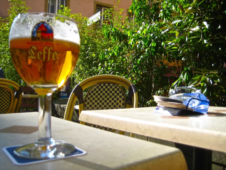 a beer in a glass at an outdoor dining table