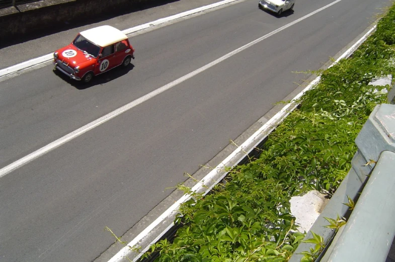 a van drives down an asphalt road next to a grassy field