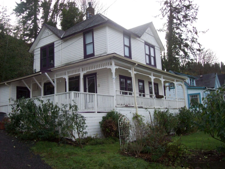 an old house is painted white and has black trim