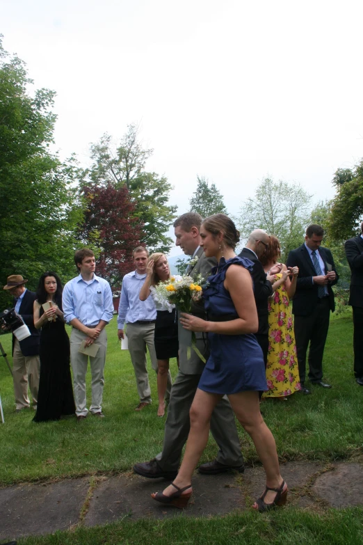 a man and woman are walking towards a group of other people