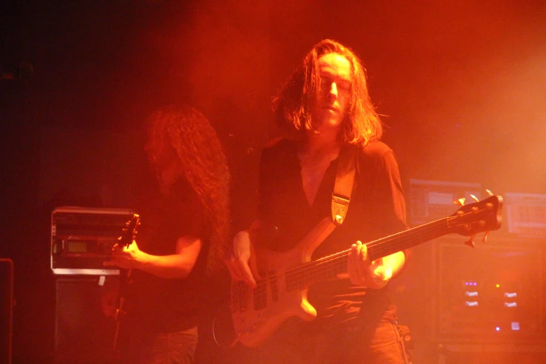 a band playing live on stage, with a guitarist and guitarist standing behind them