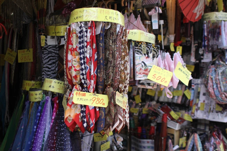 a row of scarfs, with different price tags and prices in between the ears