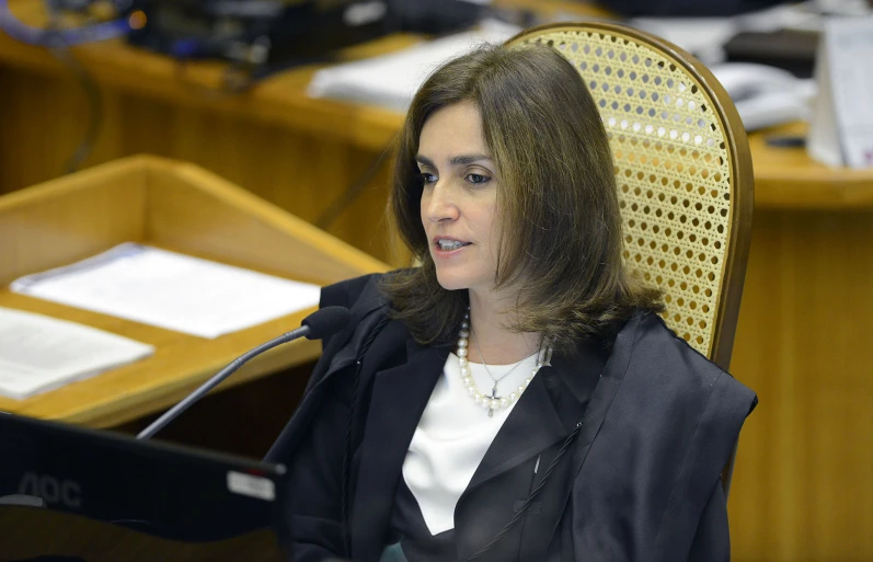 a woman is sitting in a chair looking away from the camera