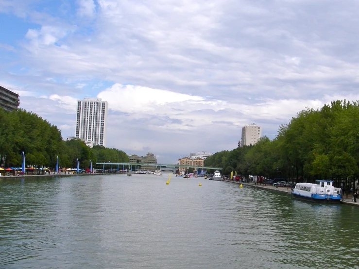 several boats traveling down a waterway next to tall buildings