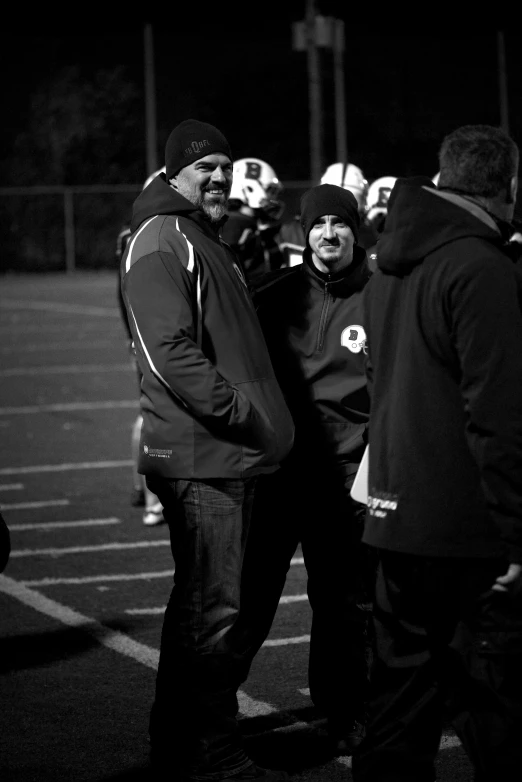 black and white pograph of football coach, head coach and referee
