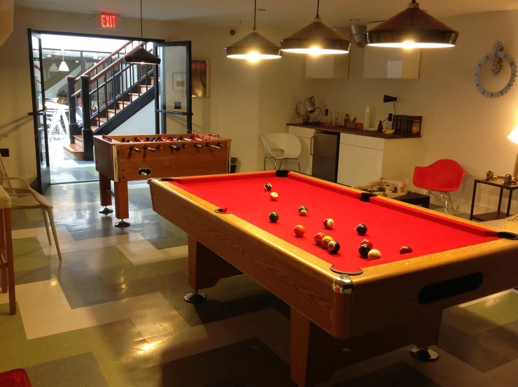 a pool table with a red cloth on it in a large room