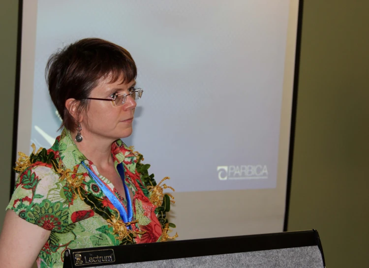 a woman in a lei is at a presentation