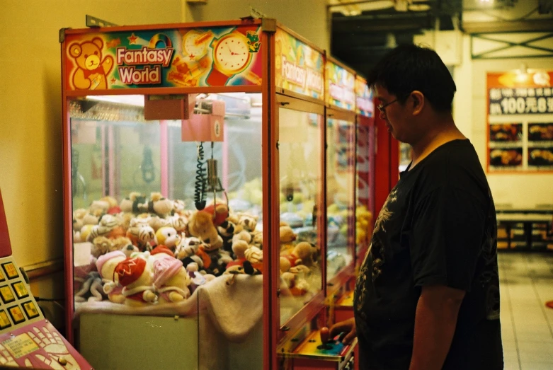 a man standing in front of a carnival vending machine