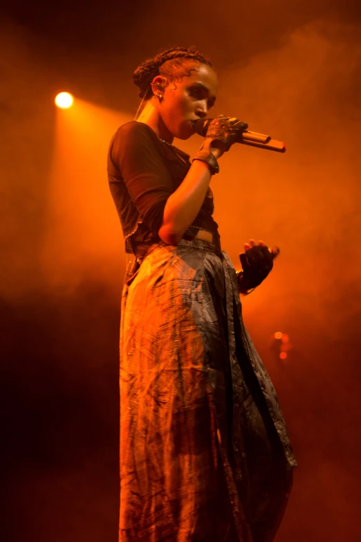 a woman is on stage and holding a microphone