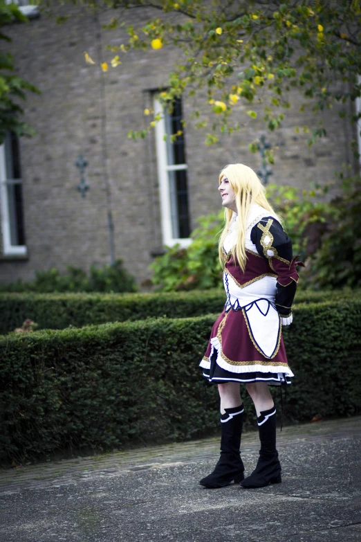 a woman dressed in costume standing by a building