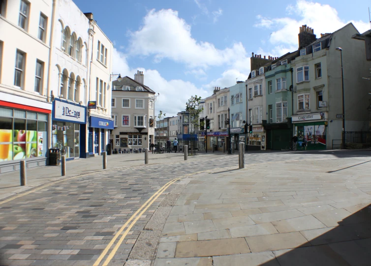 a cobblestone paved square that has shops along it