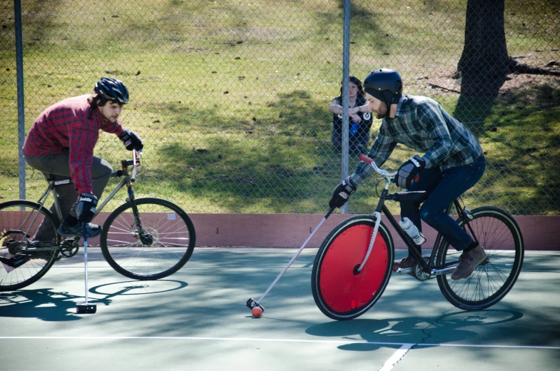 two people on bicycle with red disc on asphalt