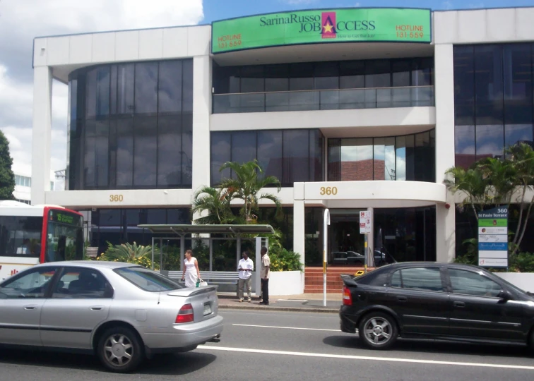 a car parked in front of a white building with glass windows