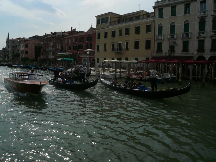 three boats on the water near a city