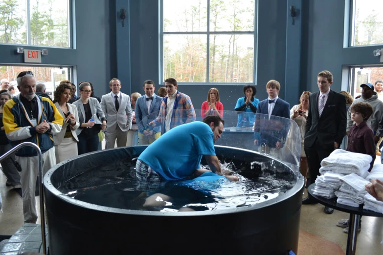 a group of people standing around a giant pool filled with water