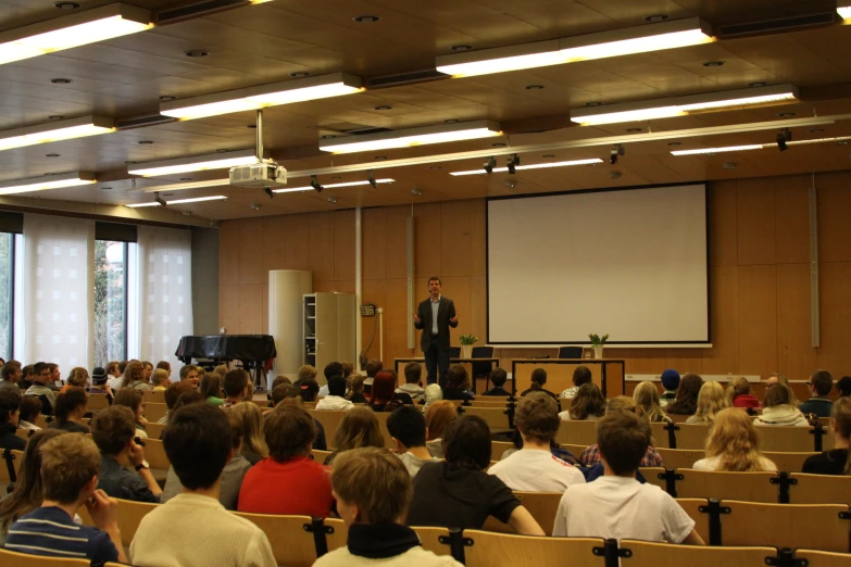 a man giving a speech in front of a group of people