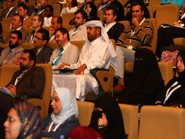 an audience of several different people sitting on seats