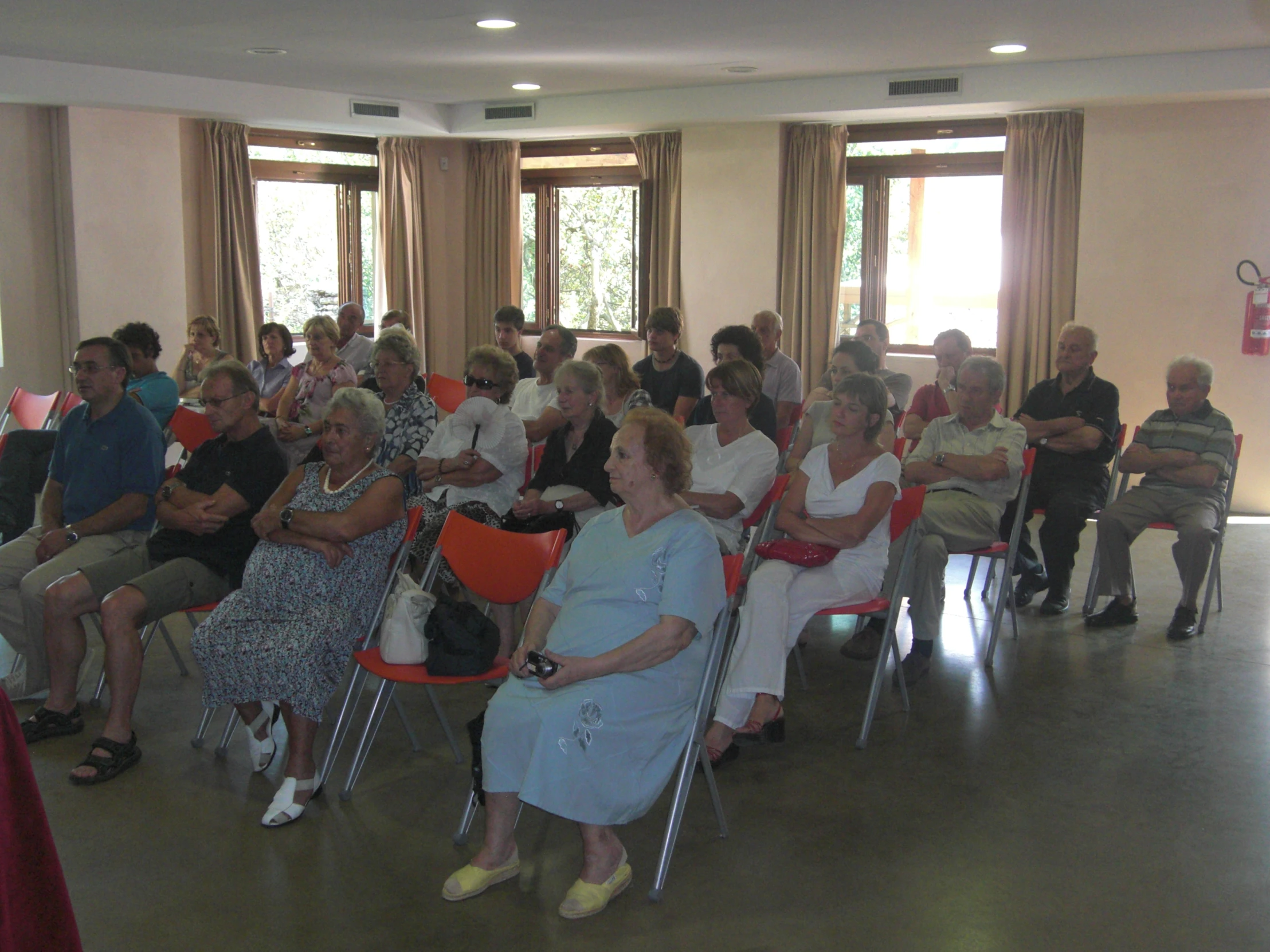 many people sitting in chairs with a number of the people wearing dress clothes