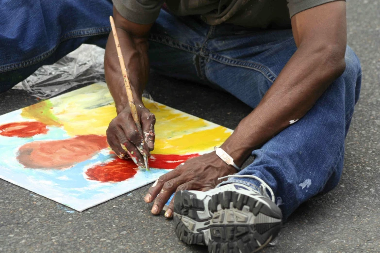 the feet of a man painting on the street