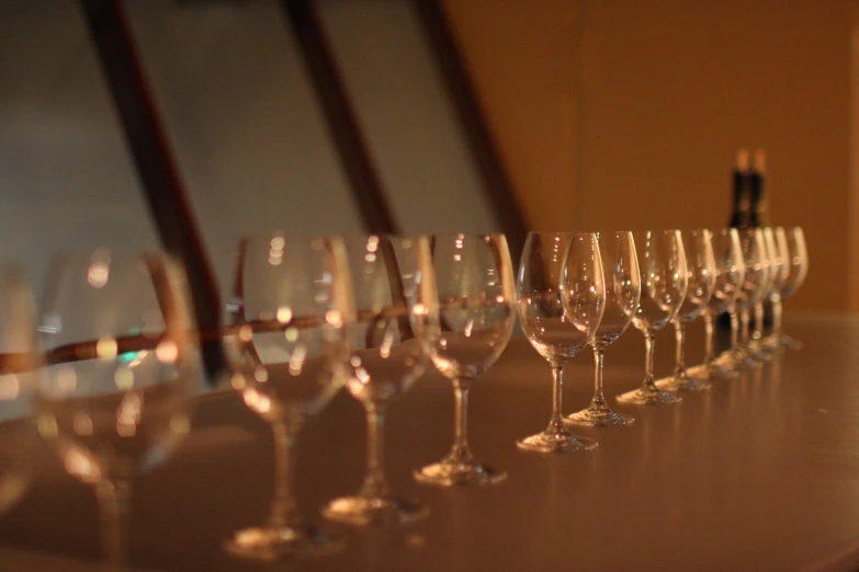 several row of wine glasses sitting on a table