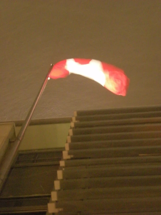 a red and white flag on top of a building