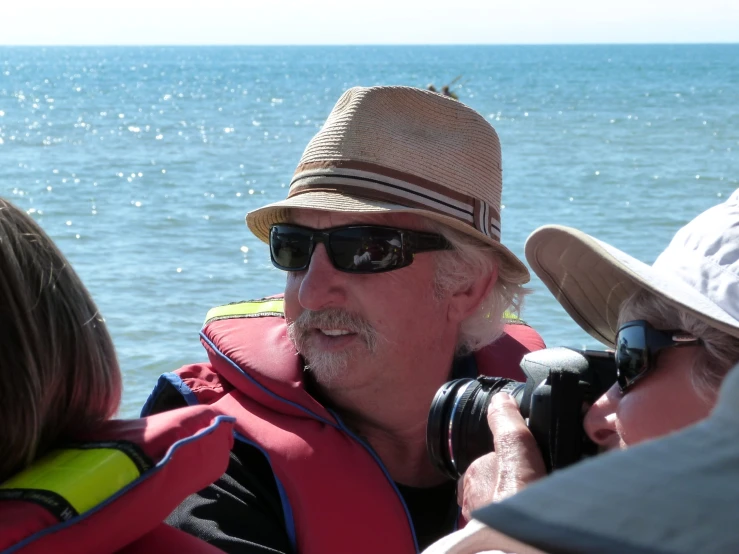 a man and woman taking pictures on a boat on the ocean