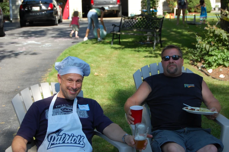 two men sitting on chairs next to each other