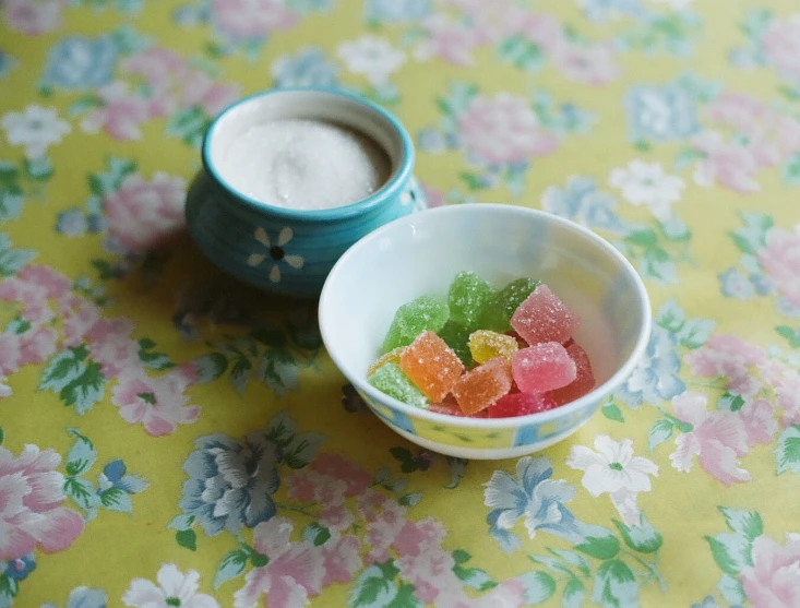 a small bowl of gummy bears and two cups