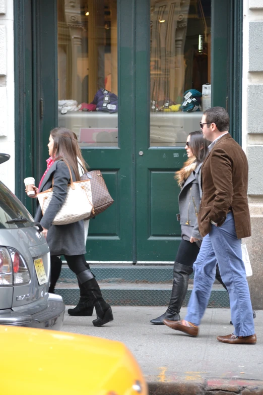 people walking down the street while the cars go by