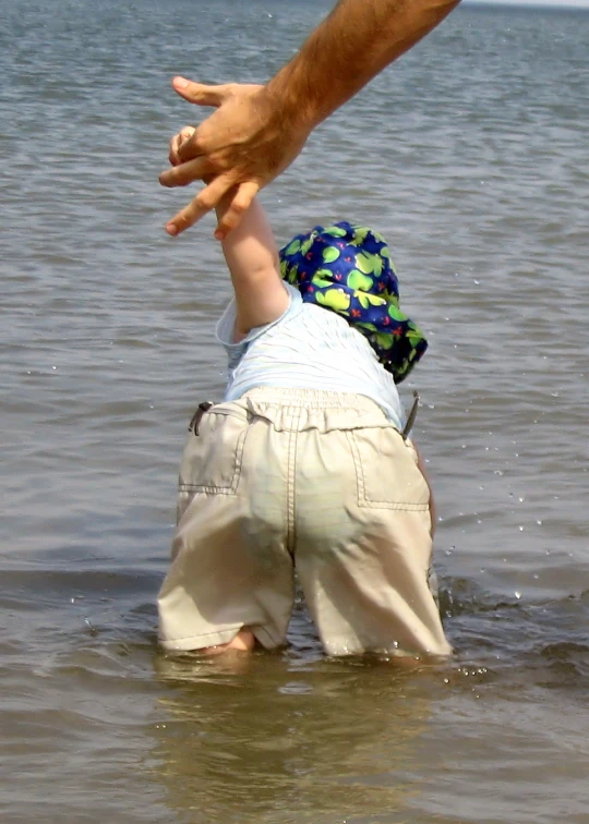 the child is playing in the water with his father